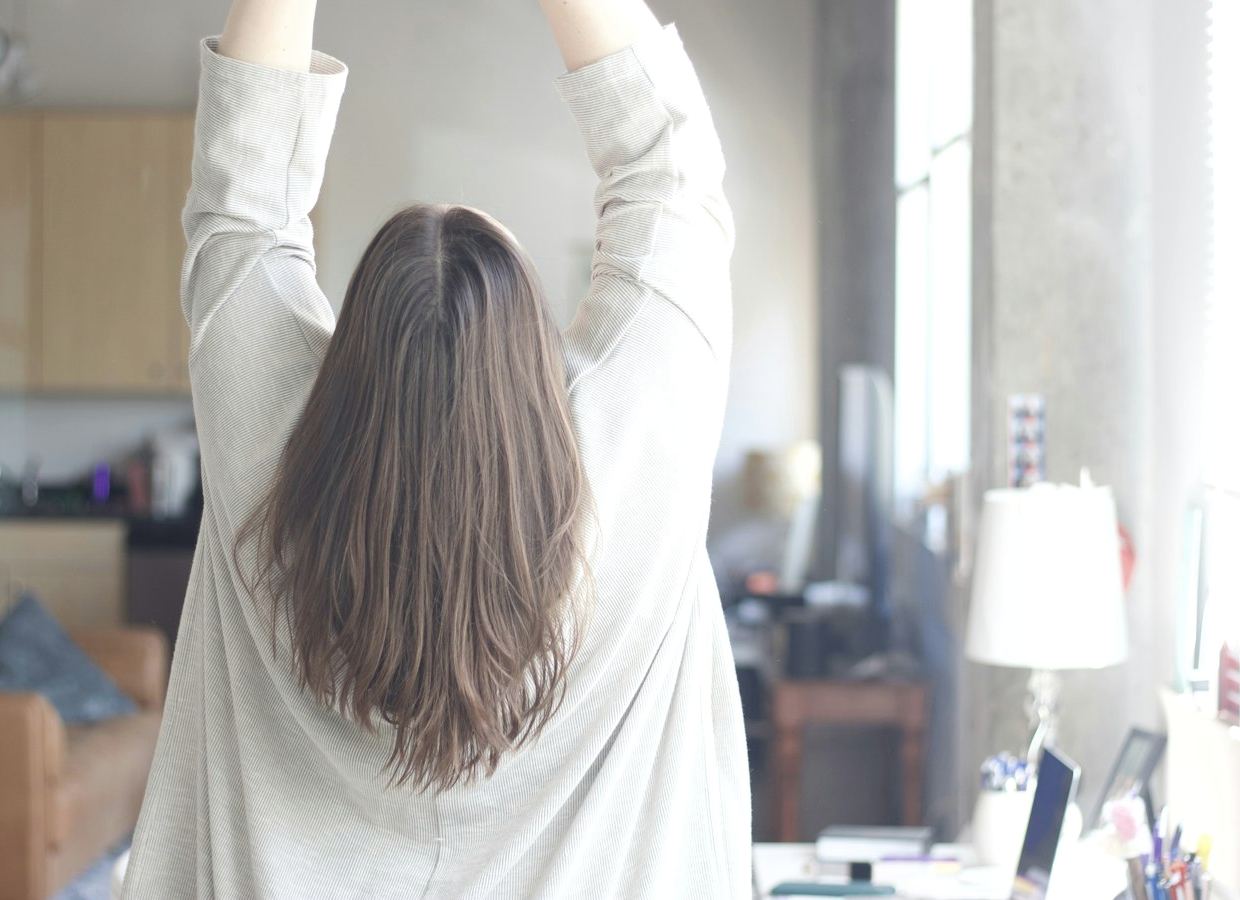 Vrouw strekt zich uit bij het raam