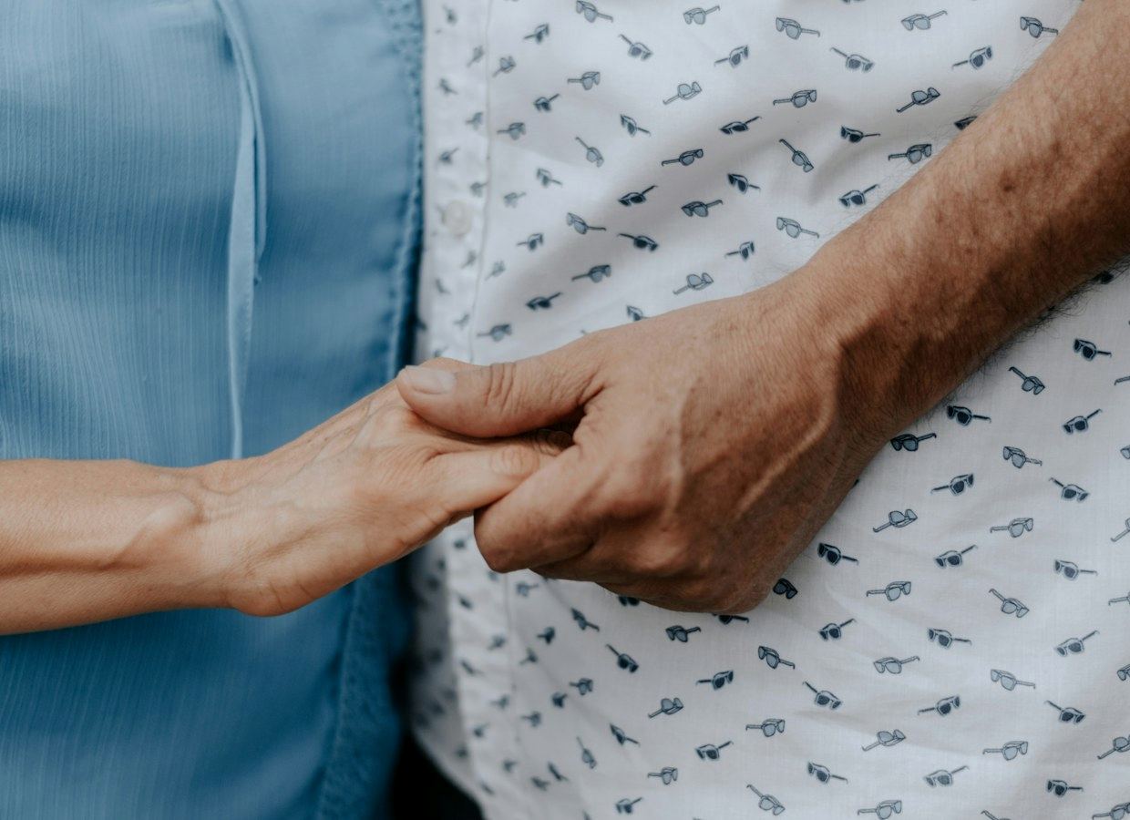 Zorgverlener ondersteunt een oudere vrouw in de tuin